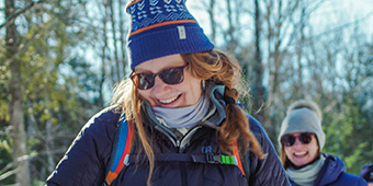 Woman in winter gear smiles outside with friends