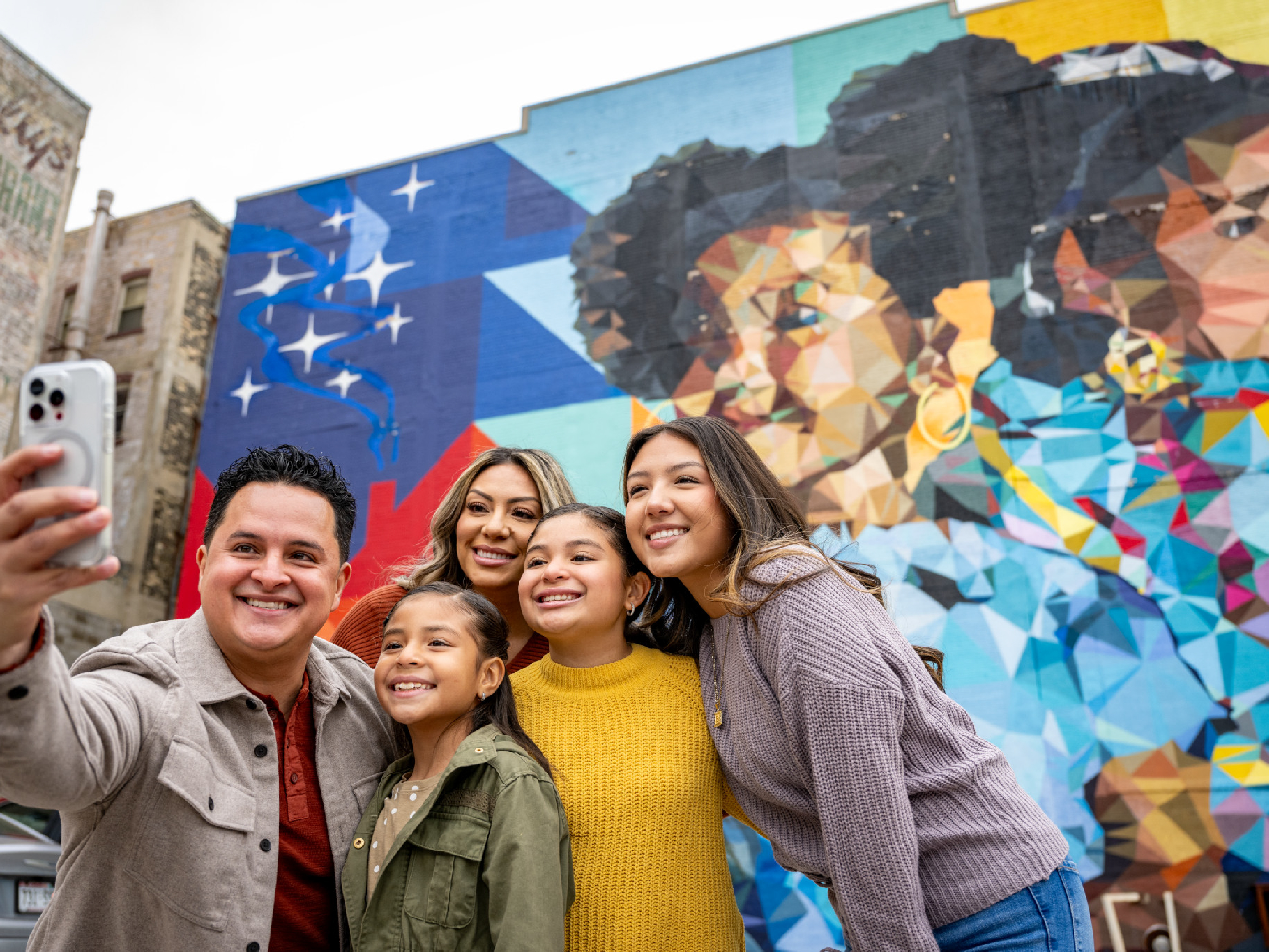 Family Take Selfie At Heart and Sol Mural By Mauricio Ramirez In Milwaukee