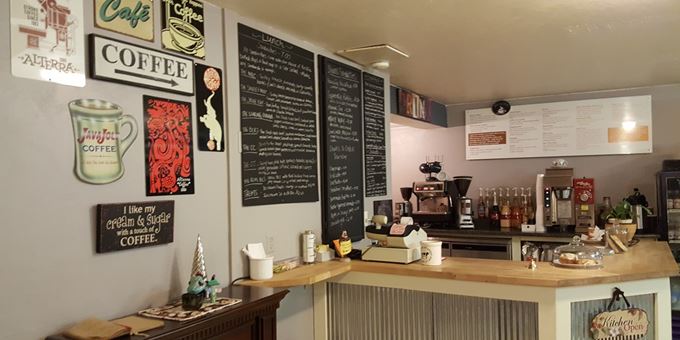 Cozy coffee place with chalkboards for messages and books for browsing.