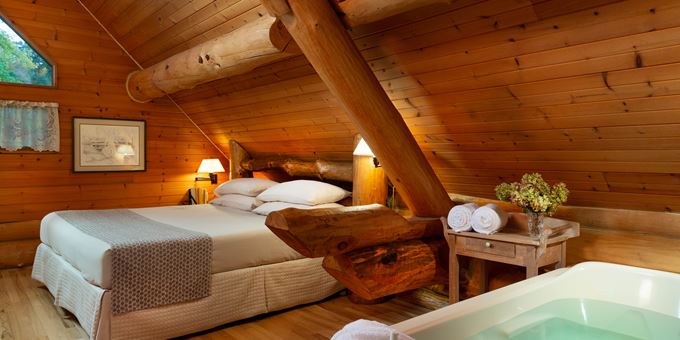 King-size bed and large BainUltra whirlpool upstairs in the loft of the Paul Bunyan log cabin at Justin Trails Resort.
