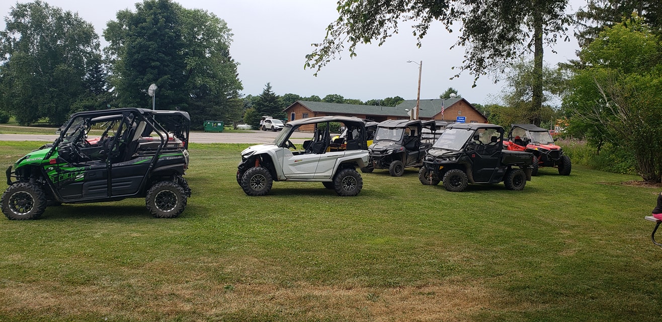 UTV riders make a stop at a local business along the Pickerel/Pearson ATV Trail, supporting the community while exploring the scenic routes of Langlade County.