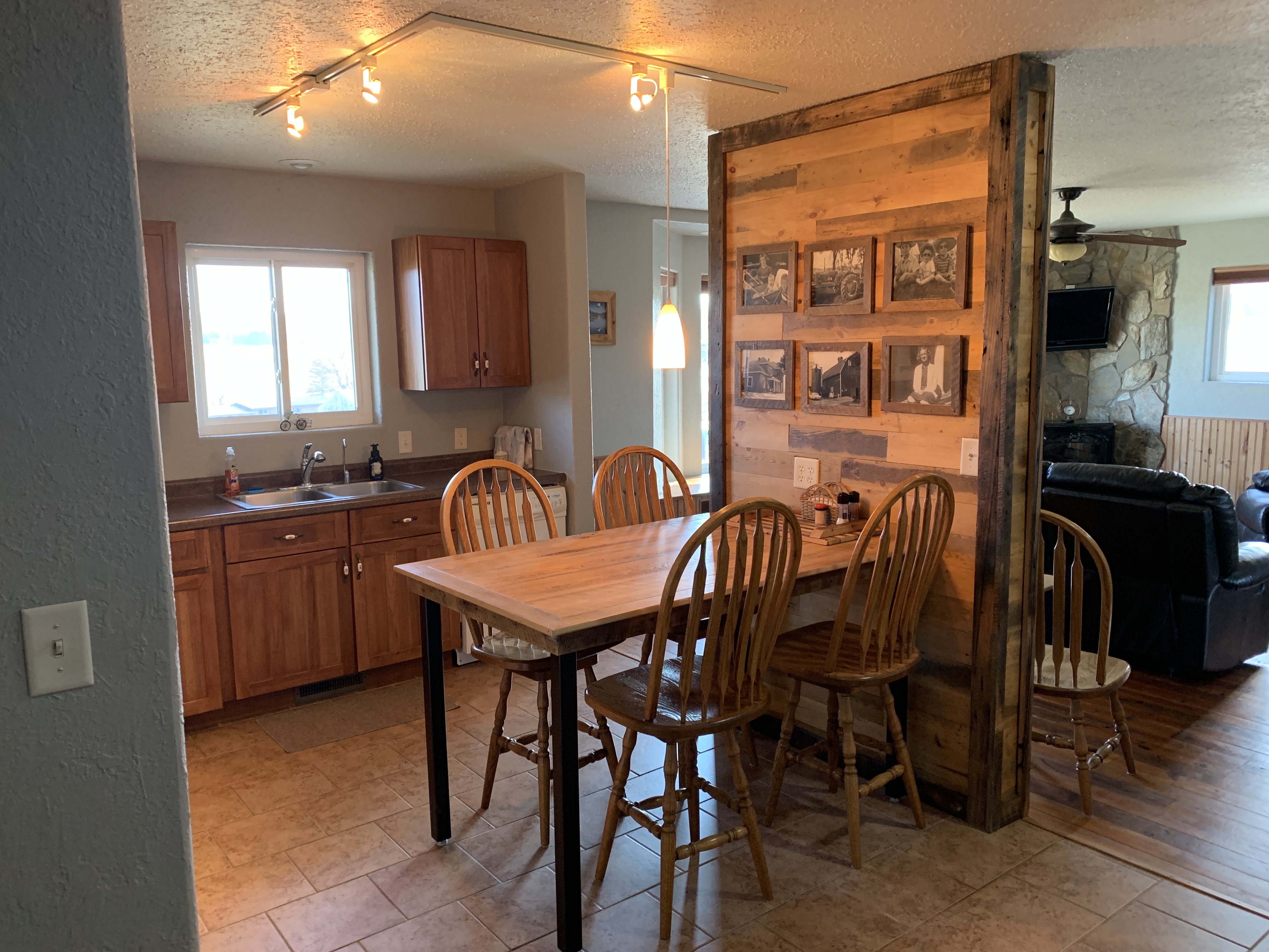 Reclaimed Wood accent wall divides kitchen/dining from living room.