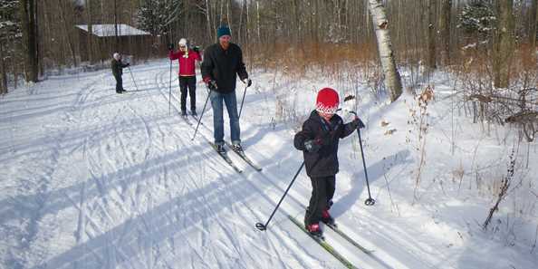 Family leaving Michelle&#39;s Lodge at Moccasin Lake to go cross-country skiing.