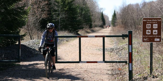 Biking through the gate on the Wolf River State Trail.