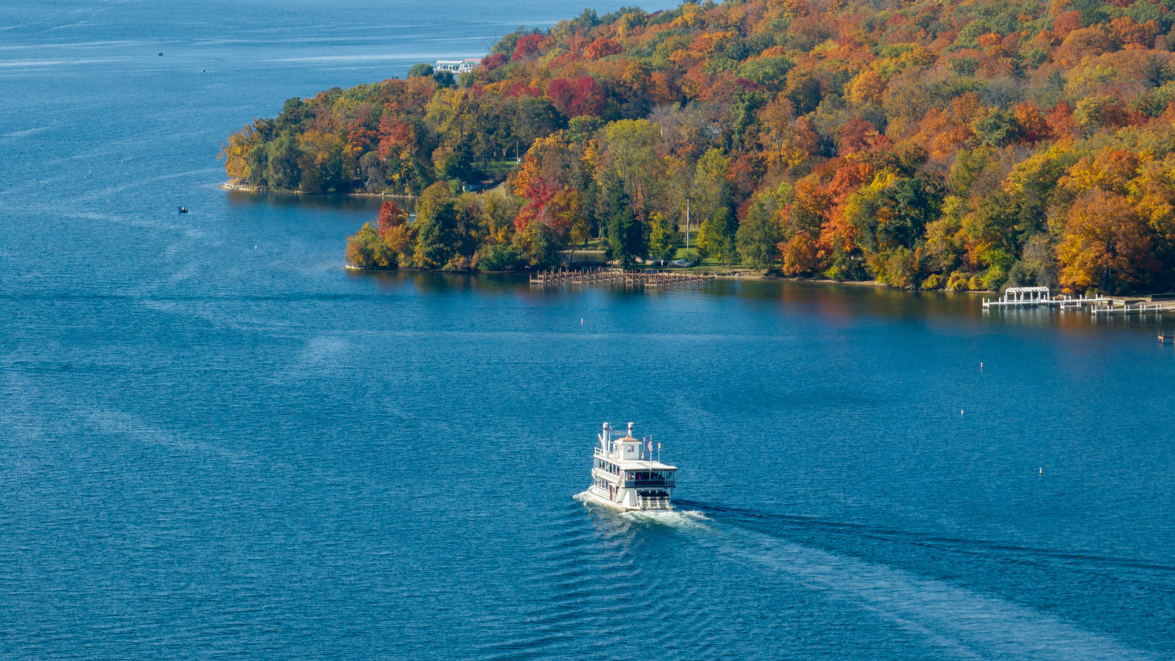 A cruise boat out on the lake with fall colors