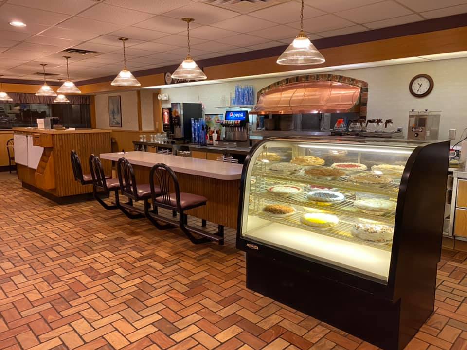 Inside Truck’s Place Family Restaurant, cozy counter seating and a well-lit display case filled with freshly made pies create a welcoming, retro diner vibe perfect for a slice and a coffee.