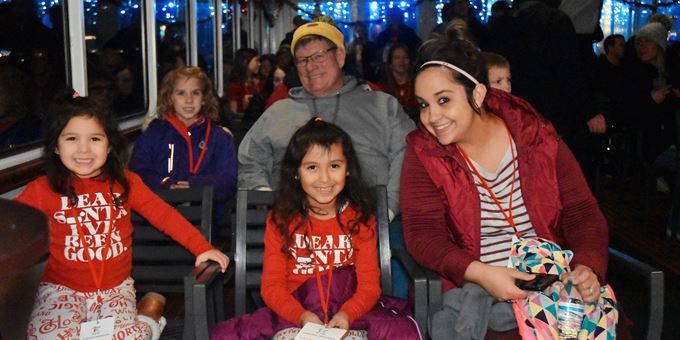 Onboard the santa cruise boat, families dressed in holiday clothes