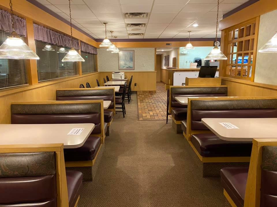 Neatly arranged booths line the dining area at Truck’s Place, offering a warm and inviting space for friends and families to gather over a hearty meal.