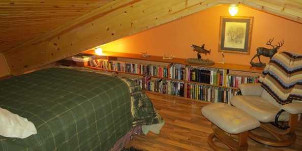 Loft in Pine Unit with double bed, and reading nook with large supply of books.
