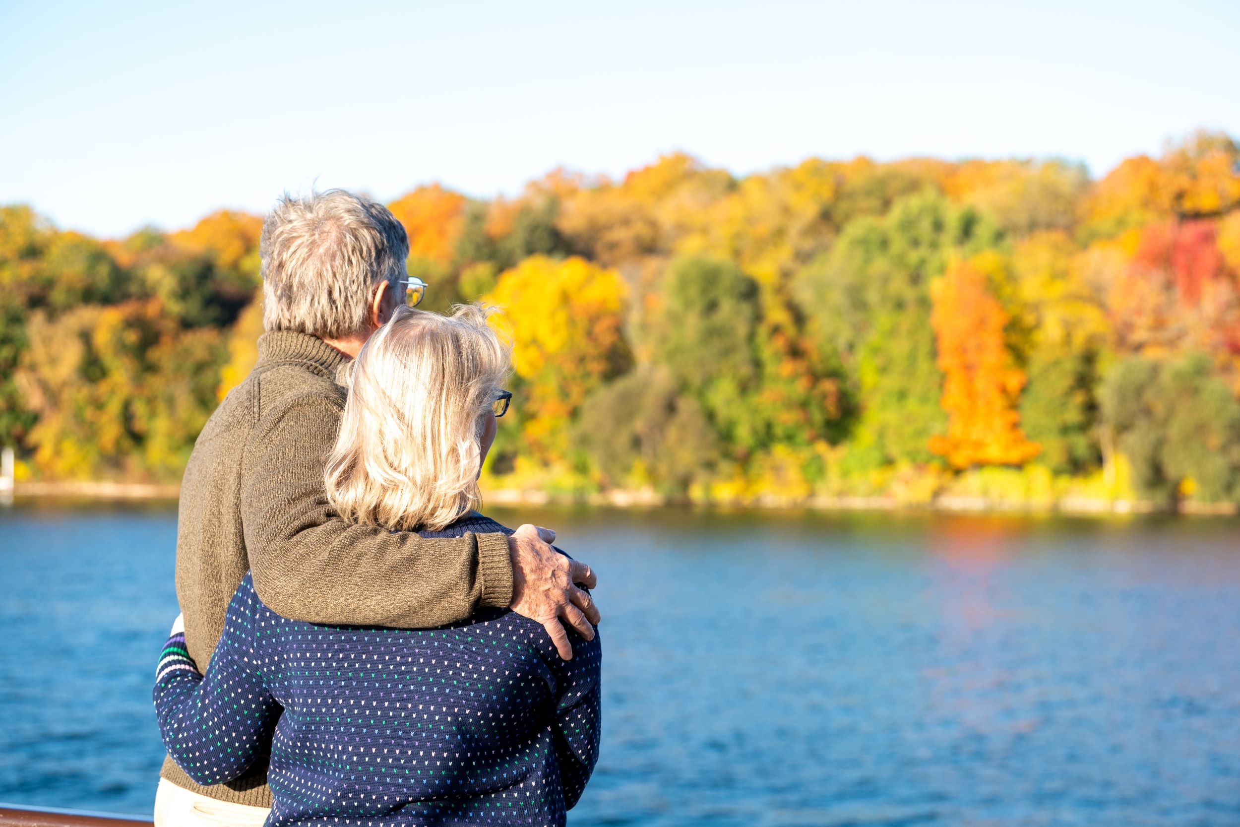 A senior couple looking out at the vibrant fall leaves