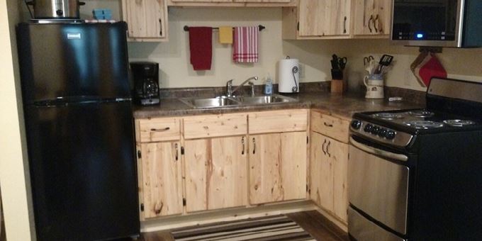The Cozy Suite kitchen is equipped with bake, cook and serving ware, and has an apartment-size refrigerator/freezer, electric oven range and microwave.