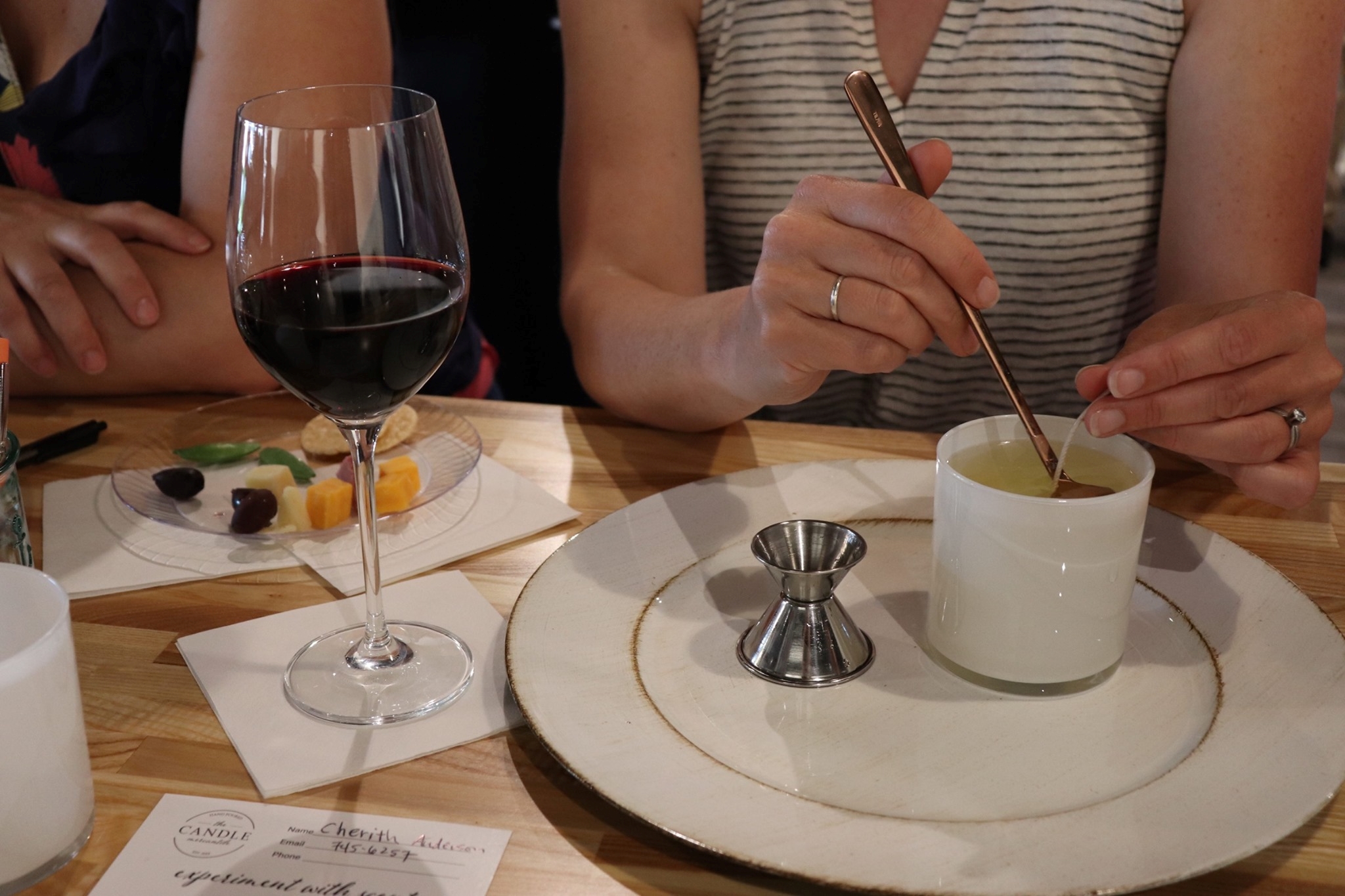 Ladies drinking wine and pouring candles.