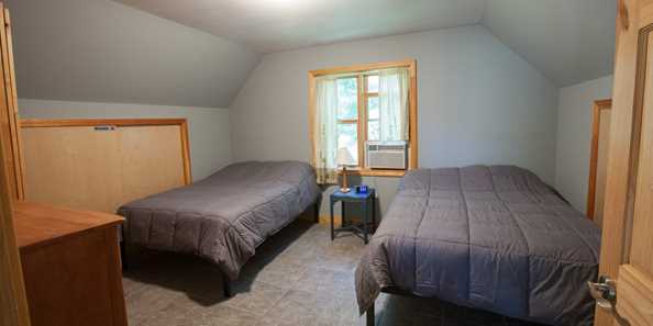 Upstairs bedroom has two full beds.