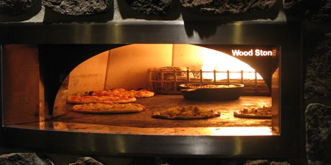 Hand made pizzas cooking in our 600 degree oven.