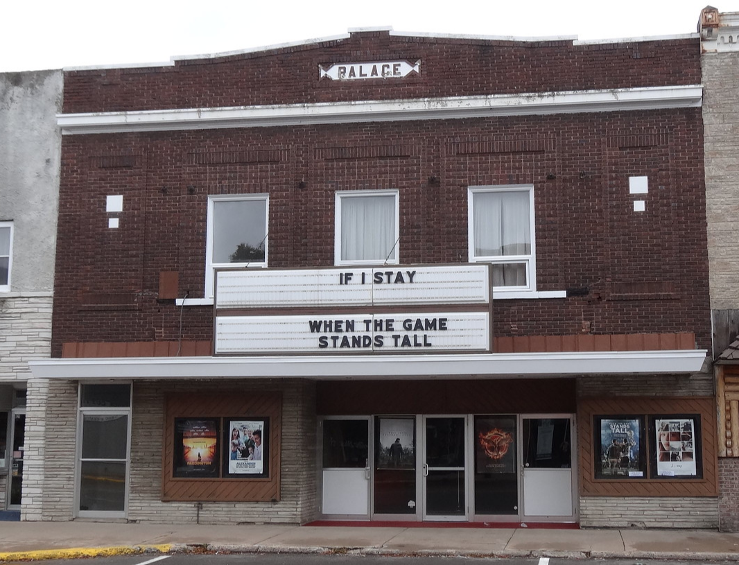 The Palace Twin Theater's brown-brick facade and sign.