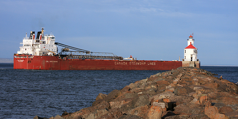 A ship passes by the Superior Entry Lighthouse on Wisconsin Point. Photo by Tom Bridge.