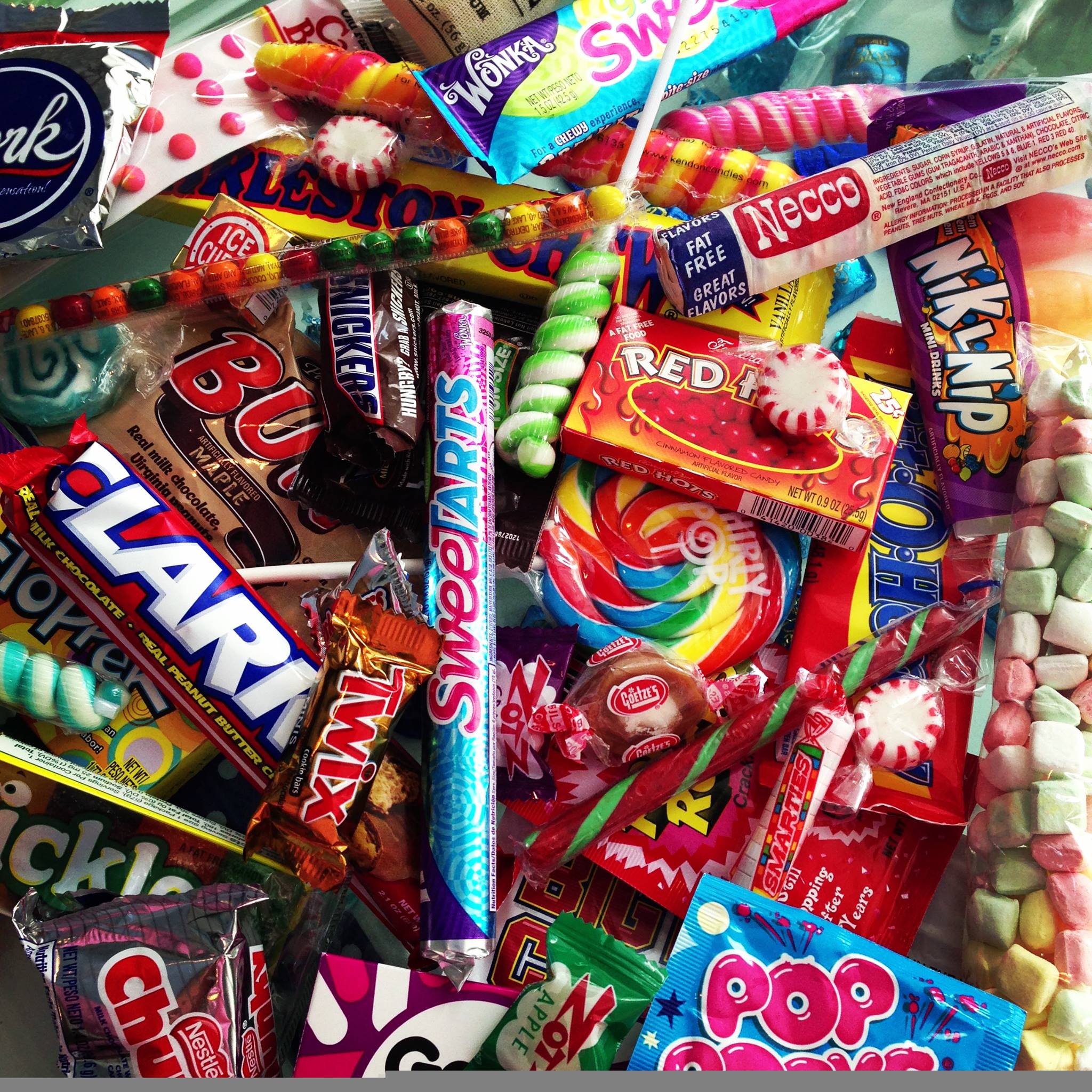 Close-up of a pile of candy, including chocolates, lollipops, and wrapped sweets.