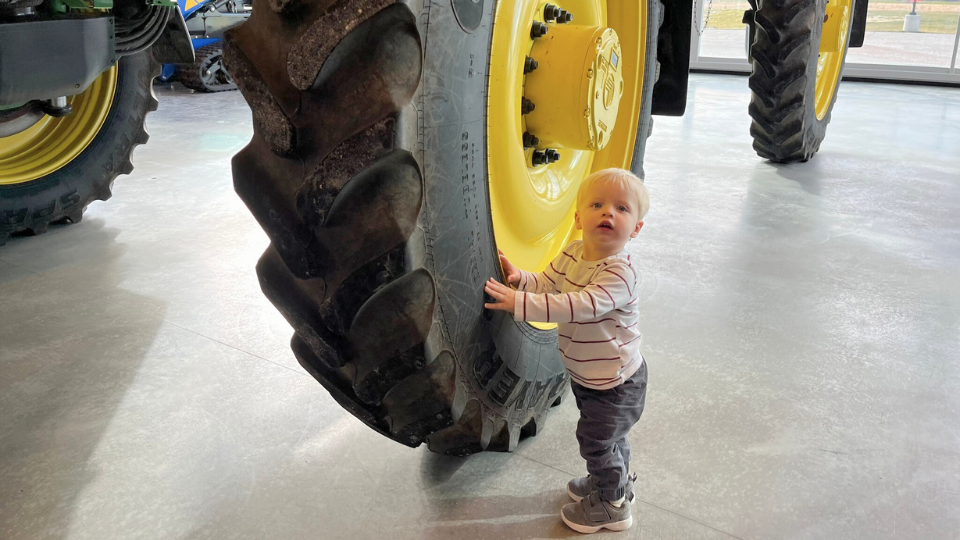 Child in front of tractor tire at Food + Farm