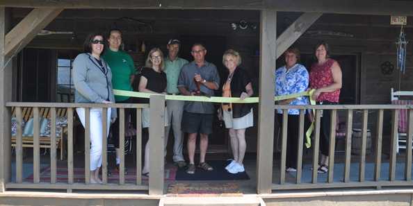 Chamber Ribbon Cutting front porch of cabin