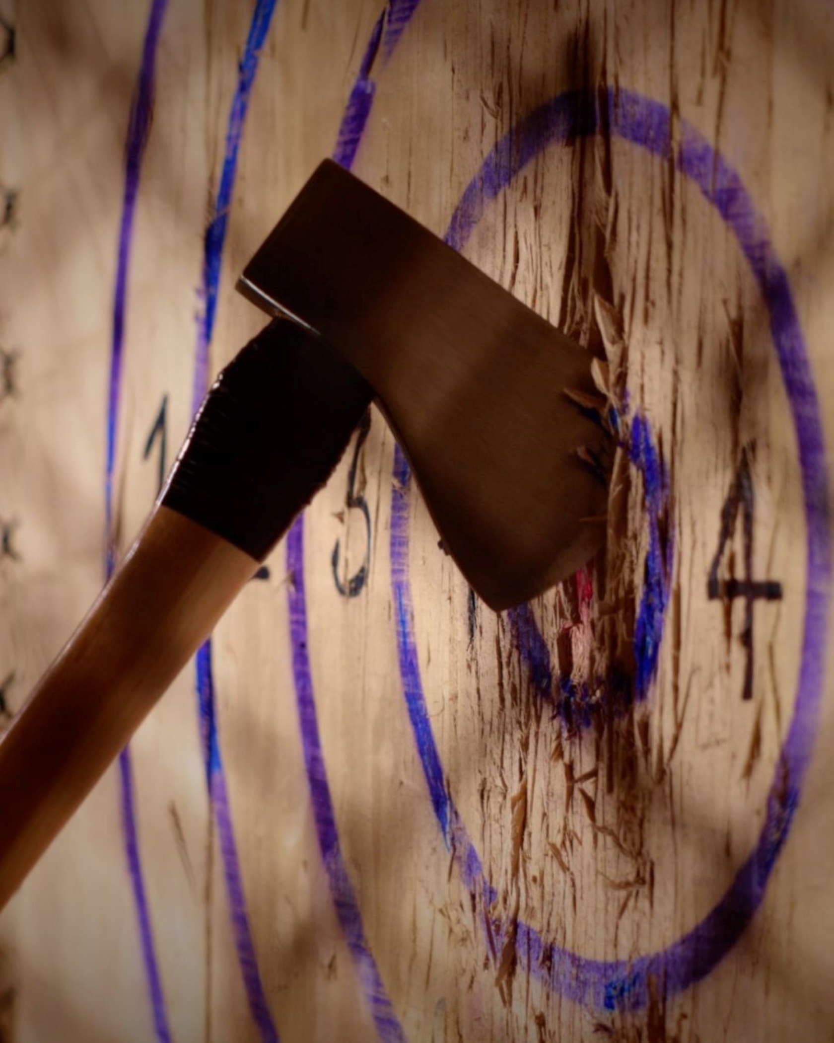 Up close picture of an axe after being thrown at the target.