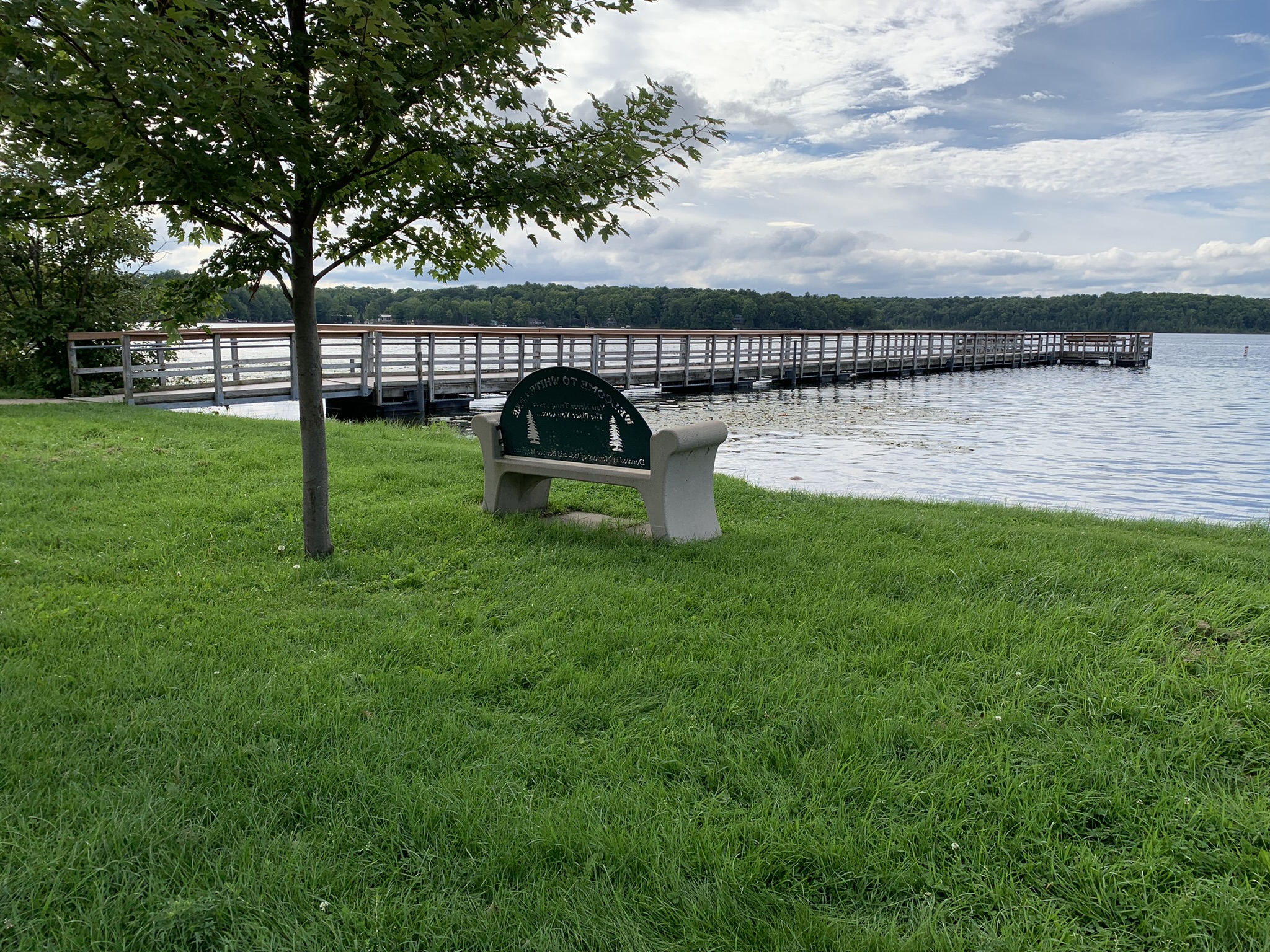 A bench near the White Lake fishing pier invites visitors to sit back, relax, and take in the peaceful scenery of White Lake.