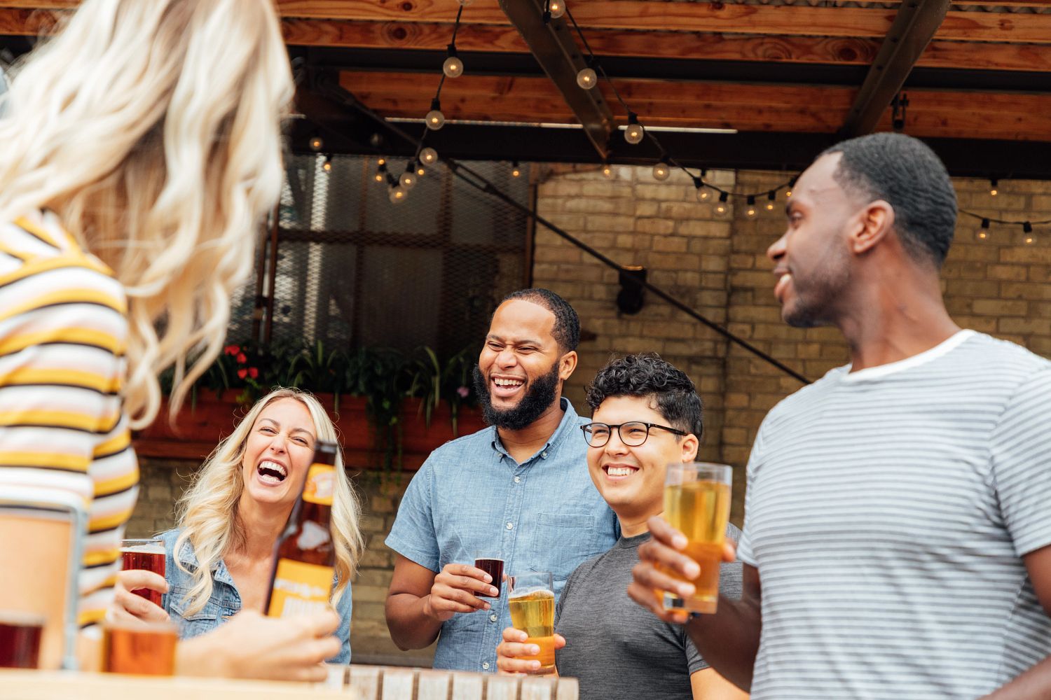 Friends Enjoy Beer On The Riverfront Patio