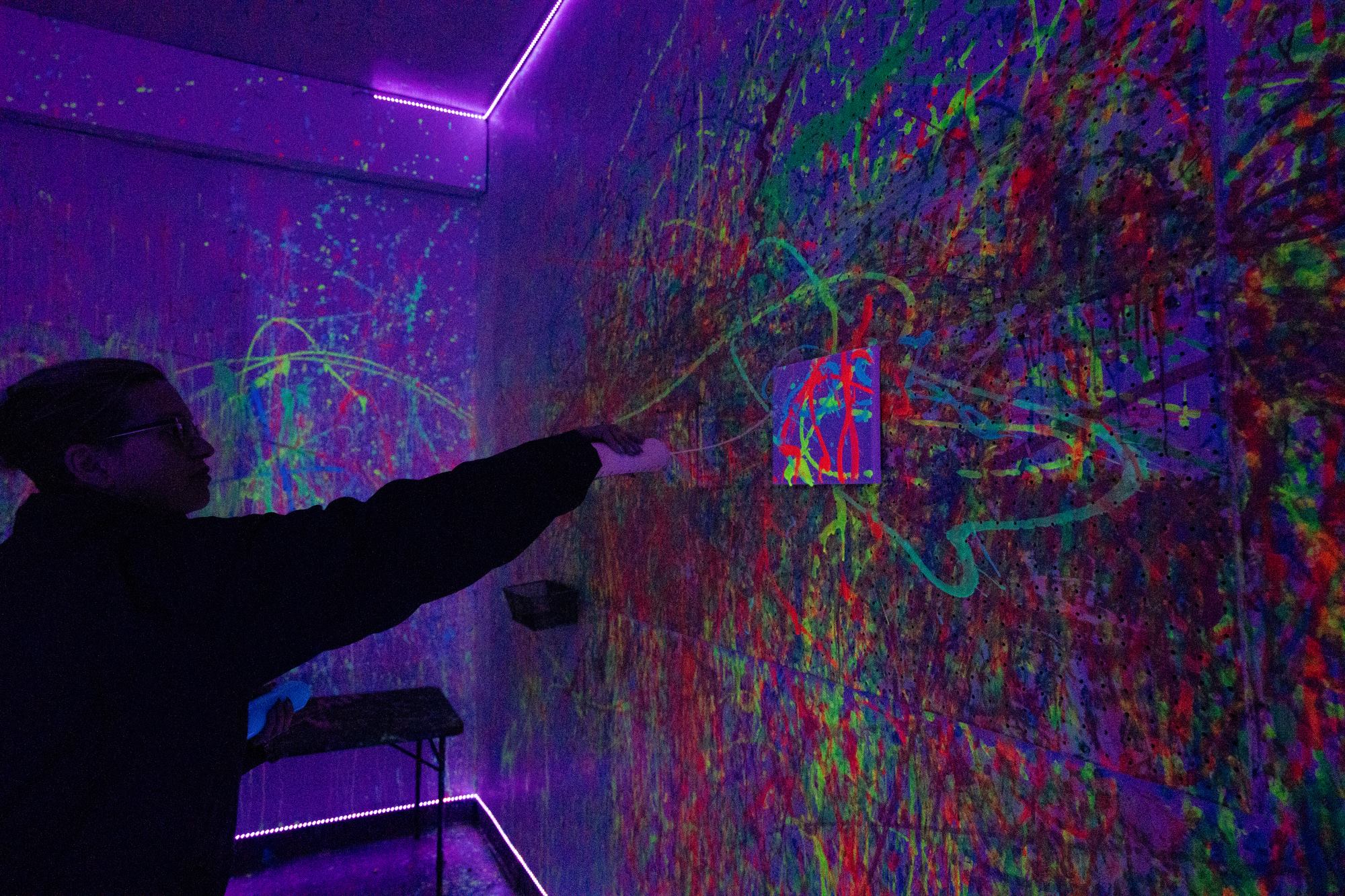 crusched paint room person on left slatting paint on canvas