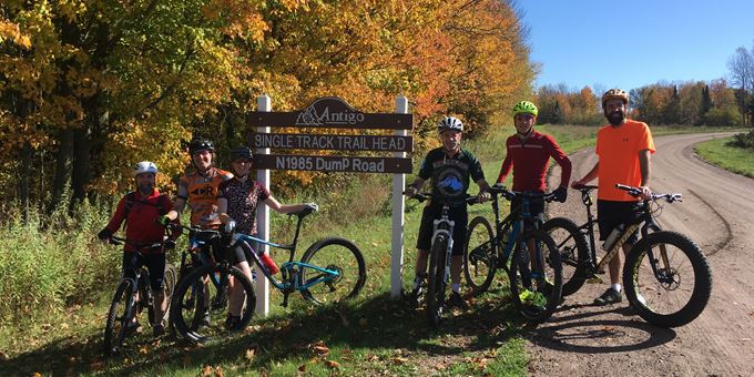 Group picture at Antigo Single Track Mountain Bike Trail Head sign.