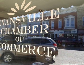 Historic Main Street is reflected in the window of the Evansville Area Chamber of Commerce &amp; Tourism.