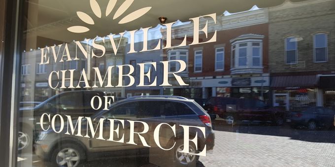 Historic Main Street is reflected in the window of the Evansville Area Chamber of Commerce &amp; Tourism.
