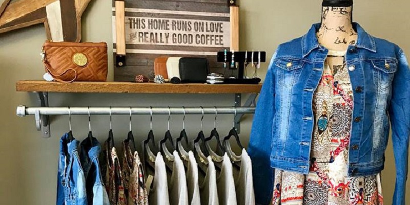 Clothes on rack with purse and jewelry above.