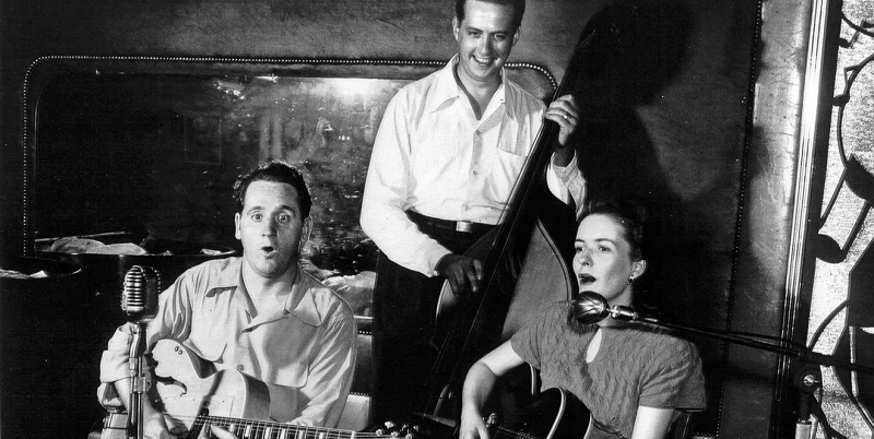 Black and white photo of Les Paul and Mary Ford performing at Club 400 in 1949 with Warren Downie playing bass.