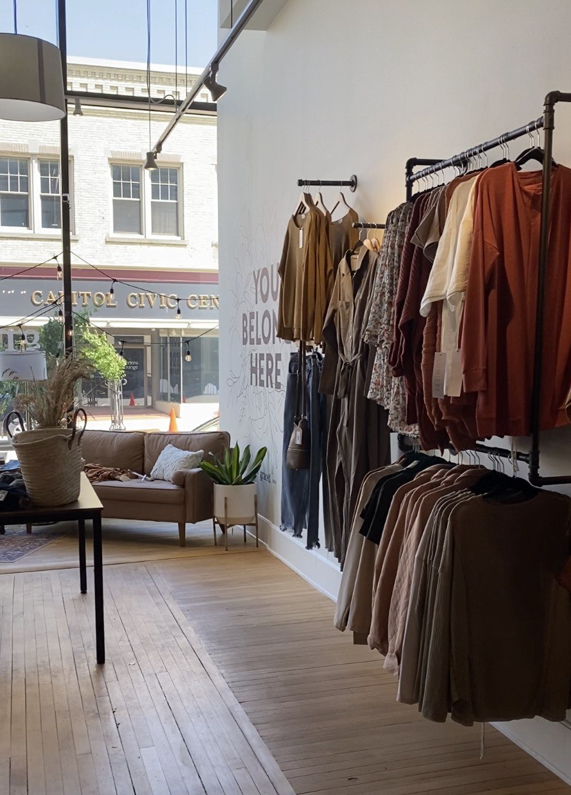 clothes on racks with window in background at graced
