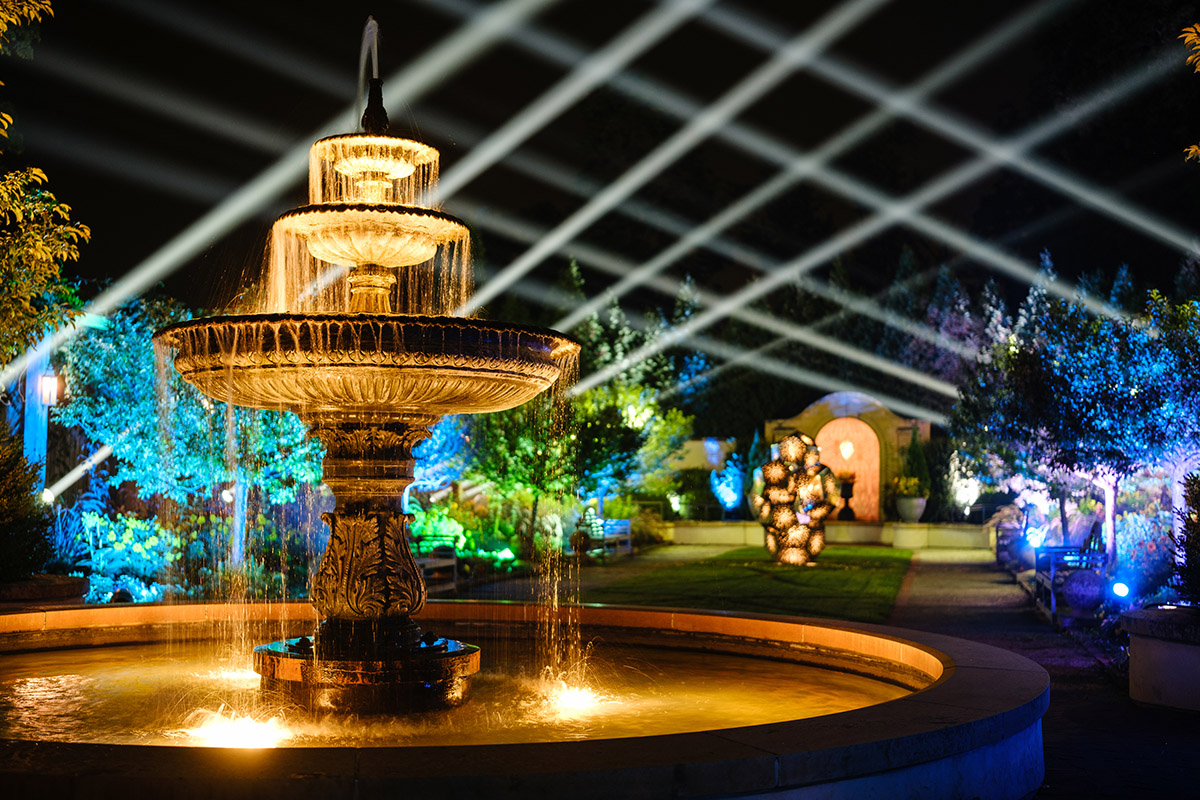 A water fountain at night with lights and lasers